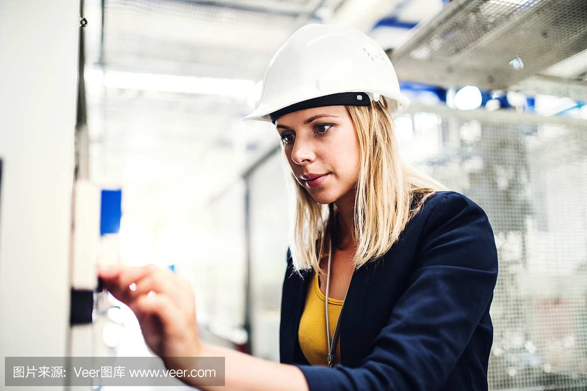 一幅女工程师在工厂检查东西的肖像。